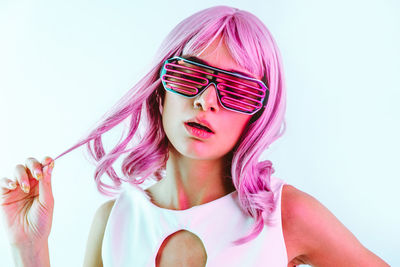 Close-up of girl wearing eyeglasses against white background