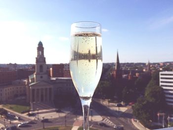 Close-up of alcoholic drink against cityscape