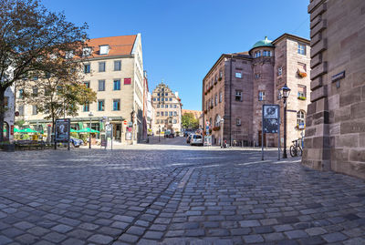 Street amidst buildings against sky in city