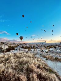 Hot air balloons flying over sea against sky