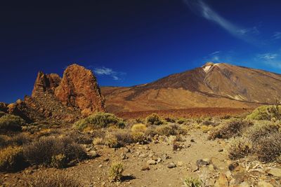 Scenic view of rocky mountains against blue sky