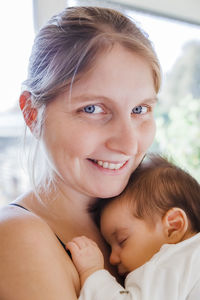 Close-up portrait of smiling mother with son at home