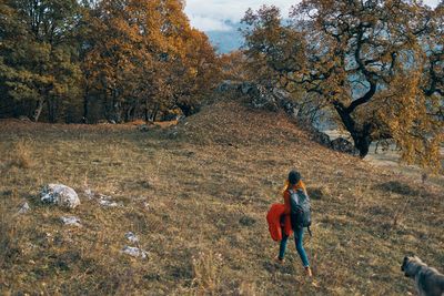 Rear view of man walking on field during autumn