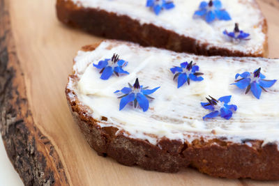 Bread, cheese and borage flowers. slice of bread spread with cream cheese.