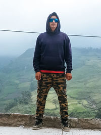 Portrait of young man standing on mountain