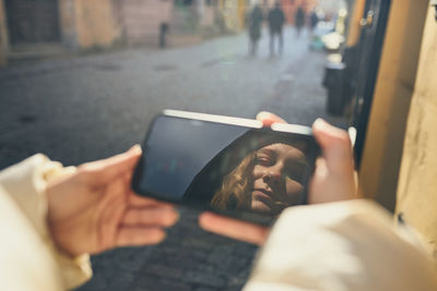 Young woman having video call, talking remotely, taking selfie photo holding smartphone