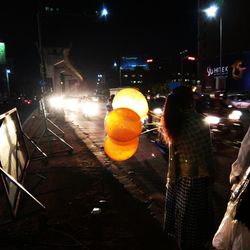 Man on illuminated street at night