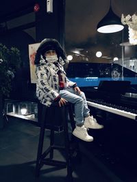 Rear view of woman sitting on chair at night