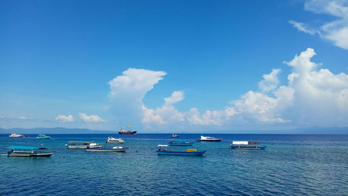 Boats in sea against blue sky