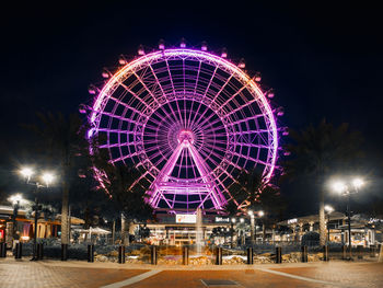 Low angle view of illuminated ferris wheel at night