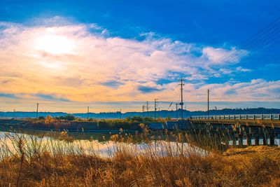 Scenic view of grass against sky during sunset