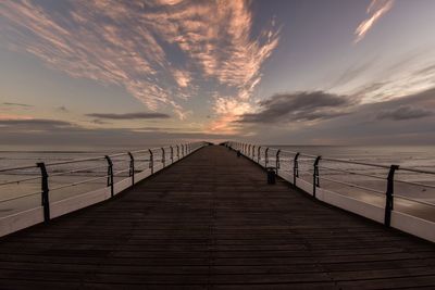 View of pier on calm sea at sunset