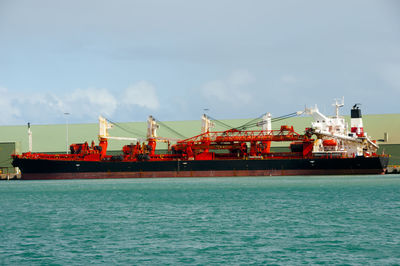 Commercial dock by sea against sky