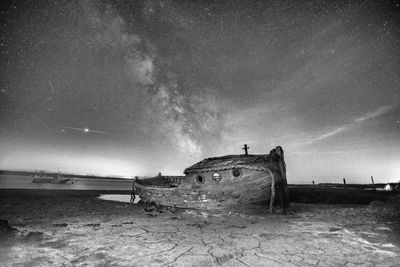 Abandoned airplane on beach against sky