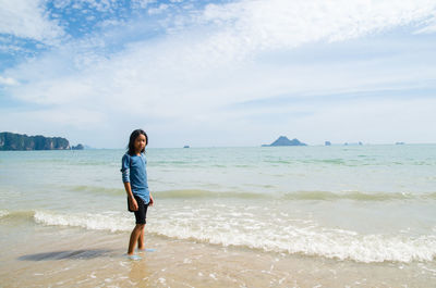 Full length of man standing on beach against sky