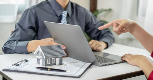 Midsection of businessman using laptop at office