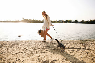 Portrait of young woman with dog at lakeshore