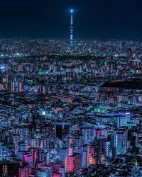 Illuminated cityscape against sky at night