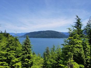 Scenic view of lake and mountains against blue sky