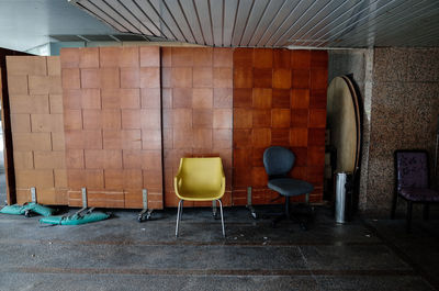 Empty chairs against wall in building