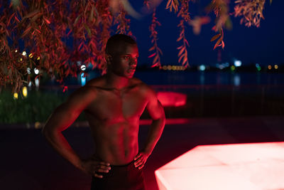 Shirtless black athlete during night workout