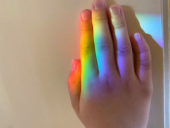 Close-up of human hand against colored background