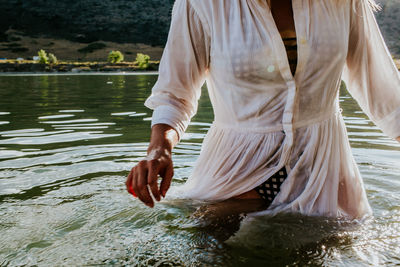 Woman walking through waist deep water with motion blue