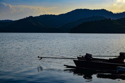 Scenic view of lake by mountains against sky