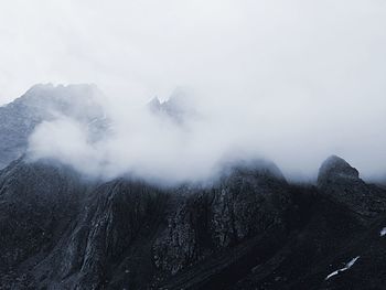 Scenic view of mountains in foggy weather against sky