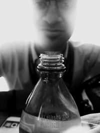 Close-up of man holding glass bottle