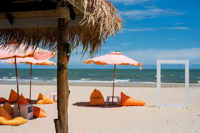 Deck chairs on beach against sky