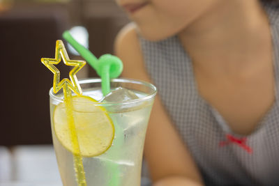 Selective focus shot of lemonade soda in cocktail glass with fancy straw and lemon slice