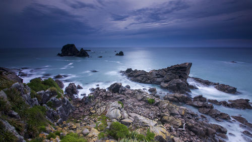 Rocks on sea shore against sky