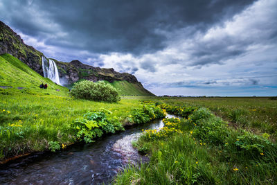 Scenic view of waterfall against sky
