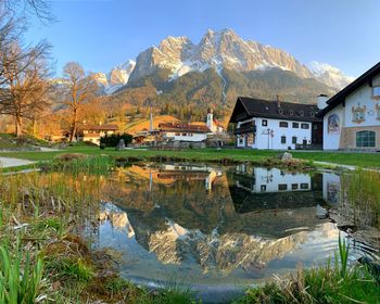 Scenic view of lake by buildings against sky