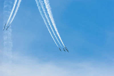 Low angle view of airplane flying against clear blue sky