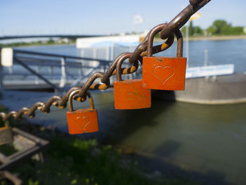 Close-up of padlocks on railing against river