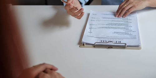 Midsection of woman holding paper