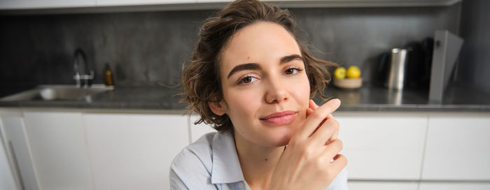 Close-up portrait of young woman in bathroom