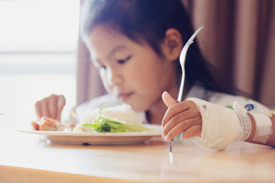 Midsection of woman holding ice cream in plate on table