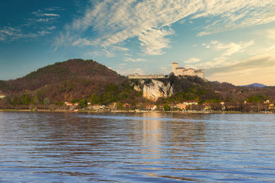 Scenic view of sea by buildings against sky