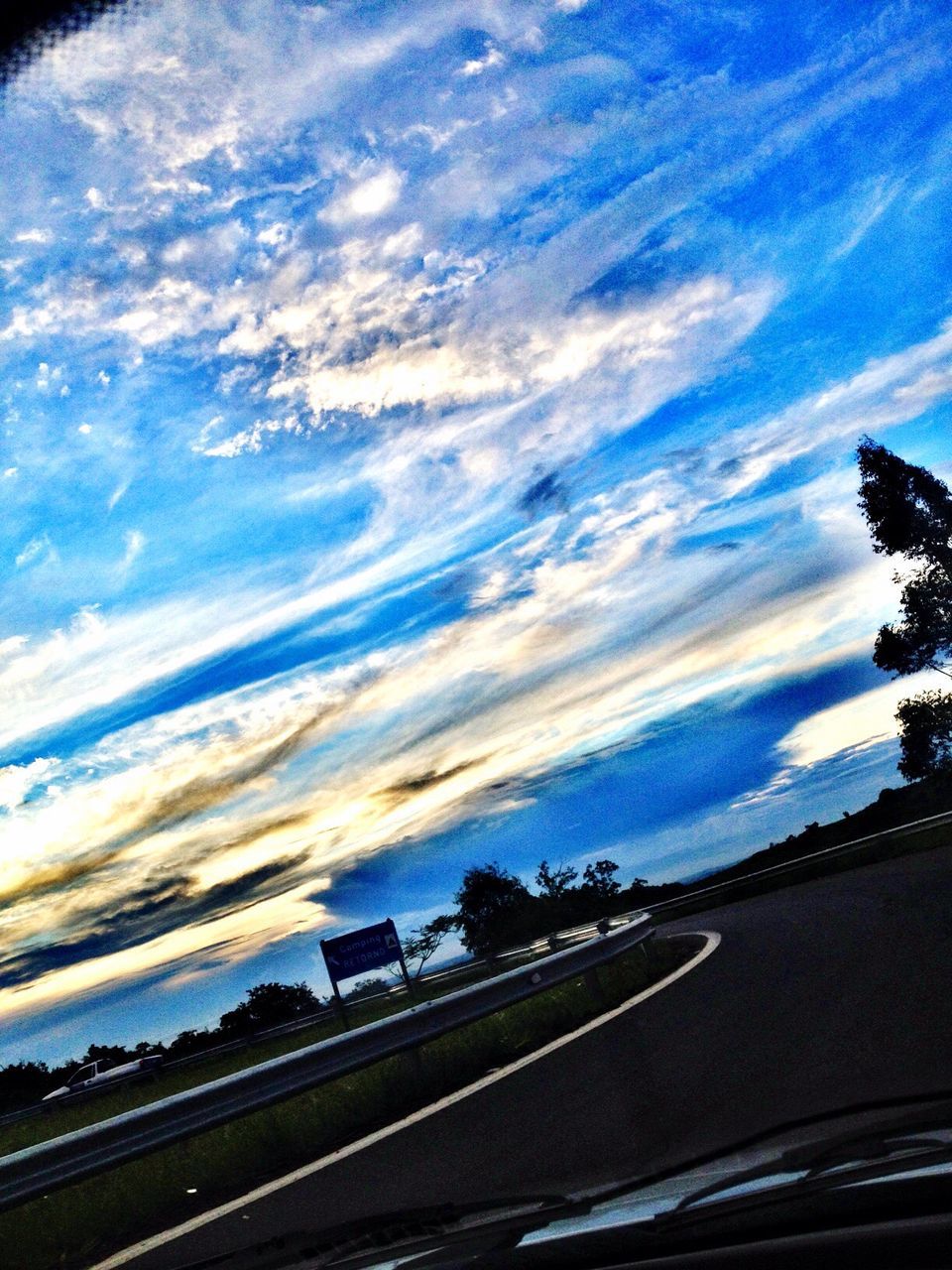 sky, transportation, cloud - sky, road, cloud, car, tree, land vehicle, silhouette, cloudy, built structure, street, building exterior, blue, architecture, nature, no people, mode of transport, dusk, outdoors