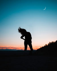 Side view of silhouette man standing against sky during sunset