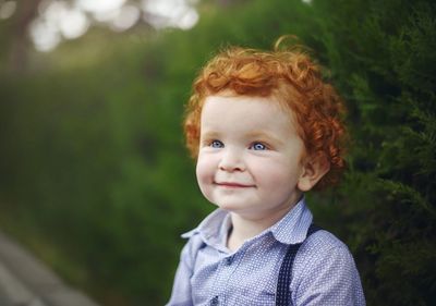 Cute smiling boy looking away at park