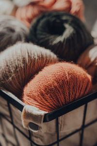 Close up of earth coloured merino wool yarn inside a basket, sunlight from the window on it.