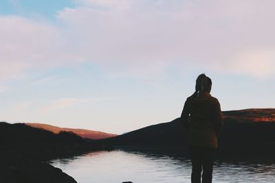 Silhouette of woman looking at sunset