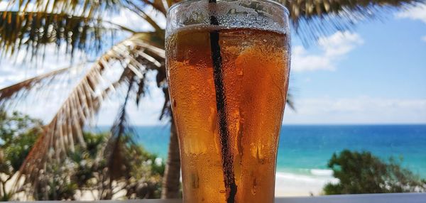 Close-up of drink on glass against sea