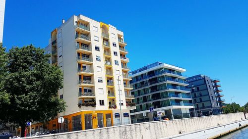 Low angle view of buildings against clear blue sky