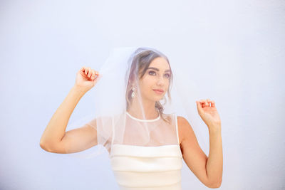 Portrait of young woman against white background