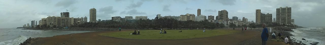 Buildings in city against cloudy sky